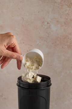 Pouring protein powder into a shaker, fitness nutrition concept