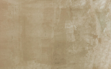 Fototapeta premium Warm beige sand stucco wall background defined by a subtle neutral texture, organic paint smudges, and faint traces of wear, serving as a versatile canvas for minimalist designs.