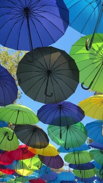 A dense arrangement of colorful umbrellas fills an outdoor display, festive decoration, summer leisure, vivid design, holiday decoration.
