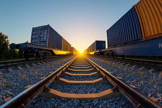 Freight trains with cargo containers on railway tracks at sunset, global supply chain network