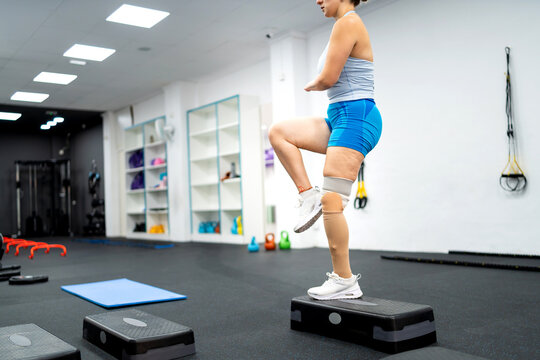 Adaptive woman stepping in gym, amputee athlete training for paralympic sport