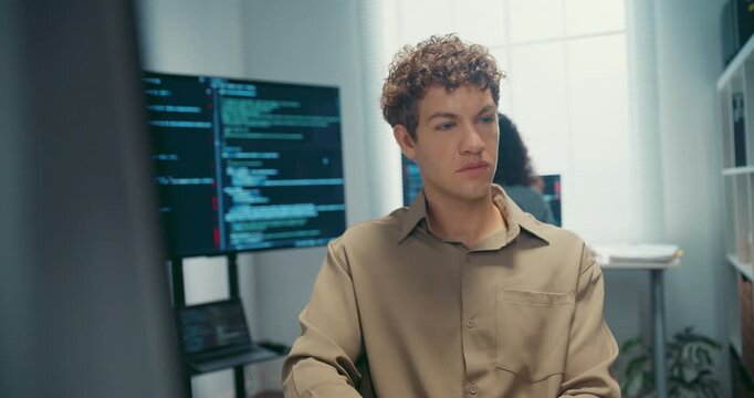 Young Caucasian male programmer working on coding in startup office workspace. Software developer artificial intelligence engineer technology, computer network digital system server security concept.
