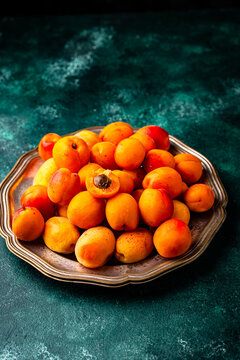 Fresh ripe apricots on dark background.