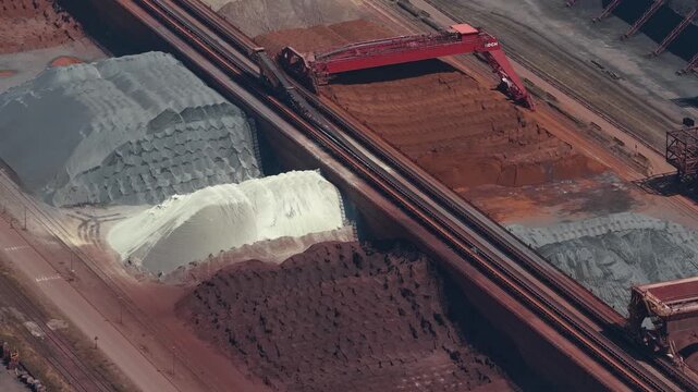 Stacker reclaimer machine handling iron ore in an industrial port