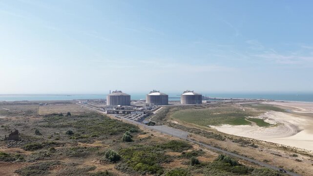 Aerial view of lng terminal and gas storage tanks on the coast