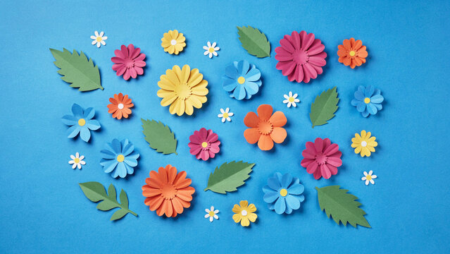 Assorted paper flowers and leaves on a blue background with floral design