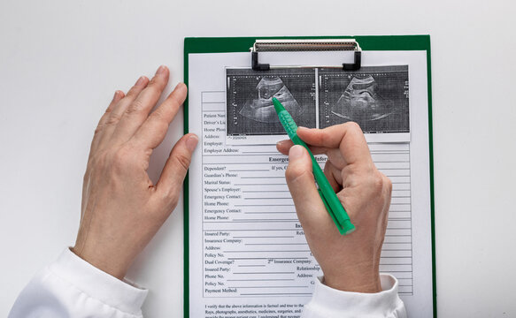 Doctor reviewing abdominal ultrasound images with patient medical records. Diagnostic imaging and clinical examination.