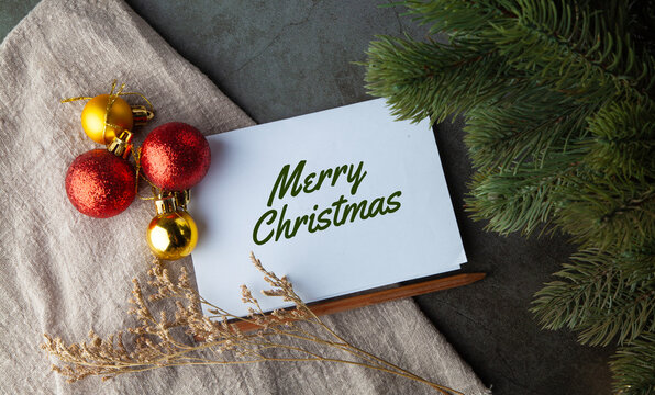 Merry Christmas card with red and gold baubles on dark background