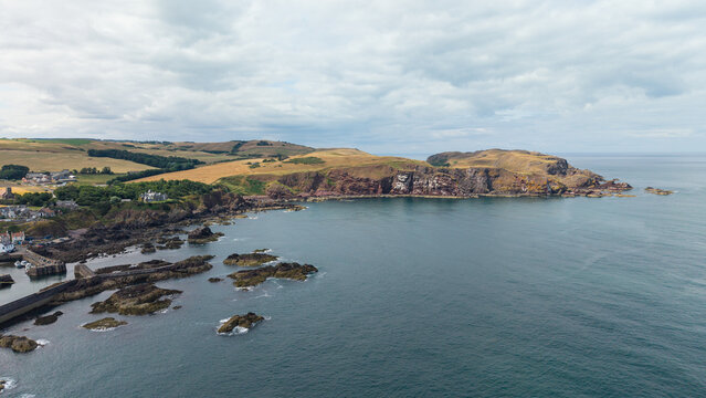 Scenic panoramic landscape of St Abbs Head coastline with dramatic cliffs, rocky bay, and North Sea shore in Berwickshire, Scotland