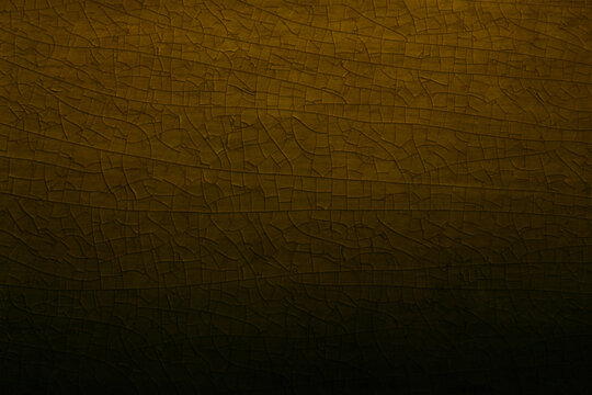 Abstract background of detailed golden cracked glaze pattern on vintage ceramic surface, featuring rich yellow ochre tones, intricate mesh texture, dark shadows, and an elegant aged antique feel.