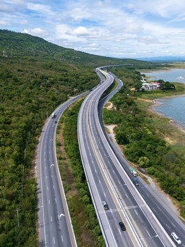 Drone aerial view of Motorway M6 Bang Pa-in&ndash;Nakhon Ratchasima expressway running beside Lam Takhong Reservoir in Nakhon Ratchasima, Thailand under cloudy skies
