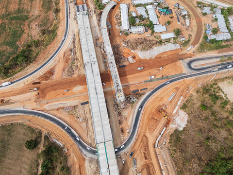 The construction site before the construction of the concrete bridge over the intersection by crane workers, tractors, and backhoes