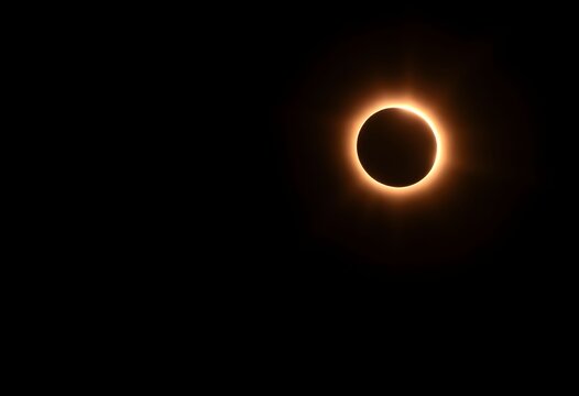 Dramatic total solar eclipse with glowing corona against dark night sky