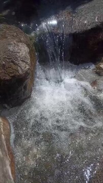 Tranquil Mountain Stream Water Rippling Over River Stones in Close Up Shot
