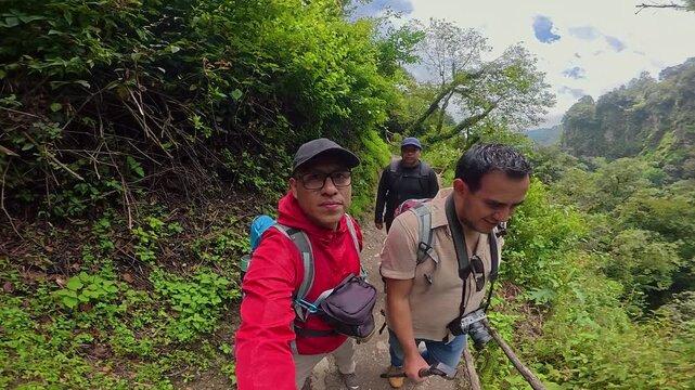 Friends hiking in a lush forest taking a selfie video