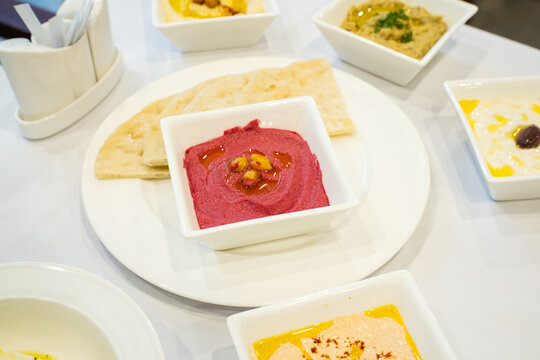 Beet hummus, Greek beet hummus dip with pita bread on a table, Greek mezes dish