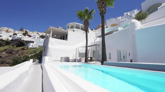 White architecture against the blue sky in Santorini island, Greece. Luxury swimming pool with blue water. Travel and summer vacation concept. 

