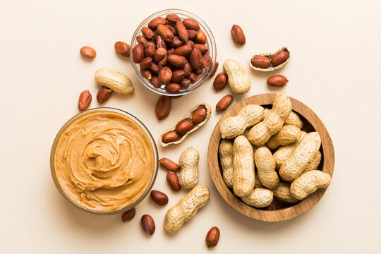 Bowl of peanut butter and peanuts on table background. top view with copy space. Creamy peanut pasta in small bowl
