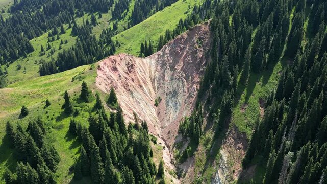 Majestic aerial view of the krasny yar clay canyon, a geological formation in the mountains near almaty, surrounded by a green forest