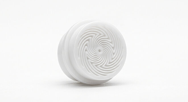 Macro photograph of a white POM plastic atomizer micro-nozzle insert with microscopic swirl channels.
