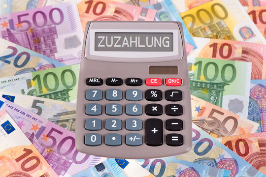 Ein Rechner mit der Aufschrift Zuzahlung im Display liegt auf vielen Euro Banknoten - FOTOMONTAGE