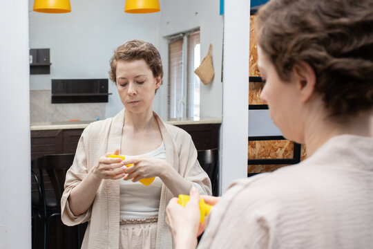 cancer survivor checks sunscreen in a mirror before a sunny day, symbolizing sensitive skin care, a mindful recovery routine and confident life after cancer treatment