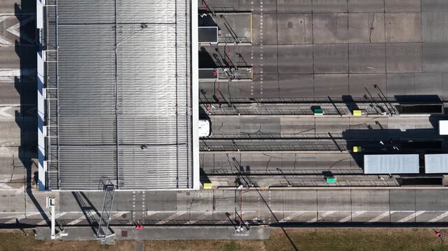 Aerial top down view of trucks passing through a toll plaza checkpoint