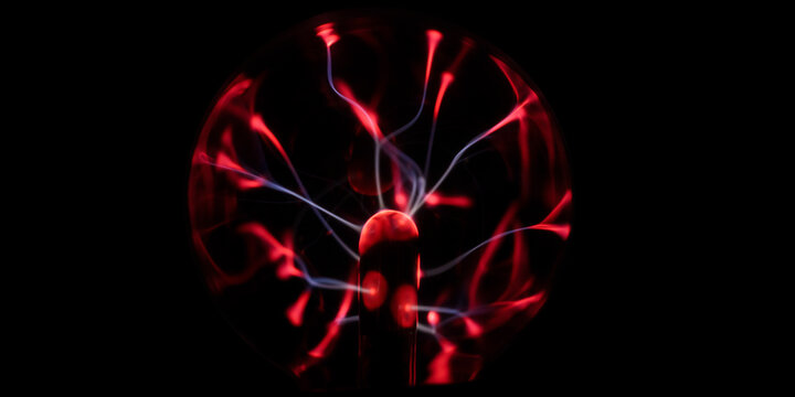Full view of a red plasma globe with branching electric arcs glowing against a black background, abstract science, electricity and futuristic energy concept