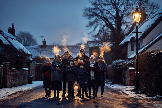 Group of people holding torches on snowy village street at night, winter outdoor procession with warm firelight and lantern glow for seasonal events