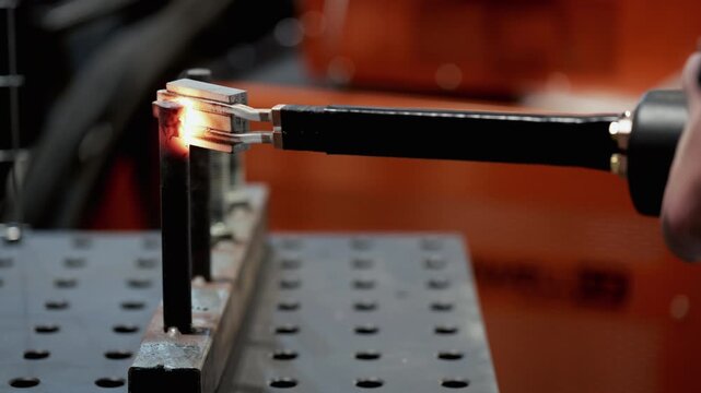 Heating steel rods with induction power making electromagnetic fields on display closeup. Modern energy efficient metalworking demonstration at exhibition