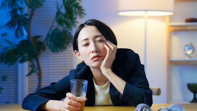 お酒を飲んで感傷に浸る女性。お酒、居酒屋、悲しい、寂しい、孤独、落ち込む、がっかり、ひとり飲み