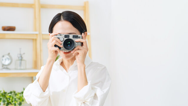カメラを持つ女性。写真、撮影、笑顔、カメラ女子、趣味、デジカメ、副業、スキル、動画、スタジオ
