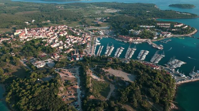 Cinematic drone flight above the historic coastal town of Vrsar featuring the marina, stone houses, church tower and Adriatic coastline