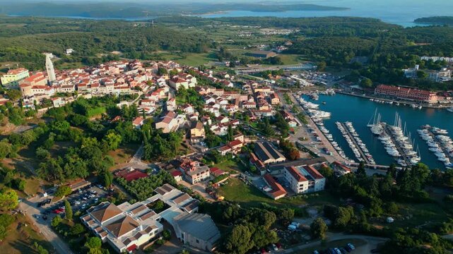 Cinematic drone flight above the historic coastal town of Vrsar featuring the marina, stone houses, church tower and Adriatic coastline