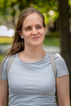 Close-up portrait of a blond haired blind women walking in the city park and smiling