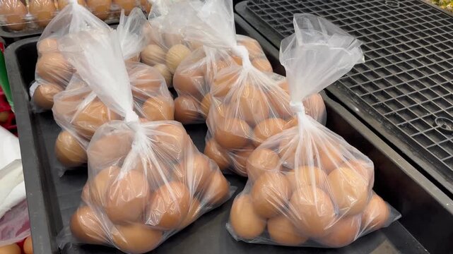 Fresh brown chicken eggs packed in transparent plastic bags at market