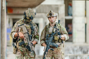 Fototapeta premium Military tactical operator holds rifle while clearing abandoned concrete building interior