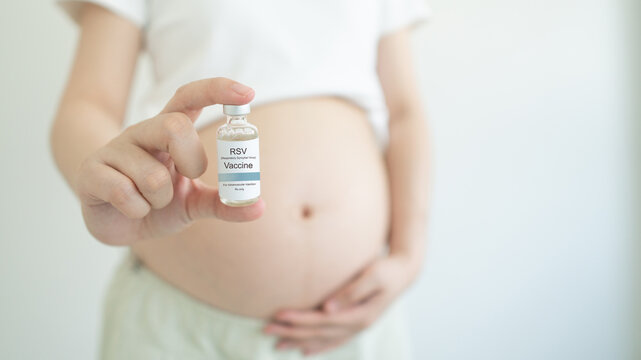 Pregnant woman hands holding RSV vaccine bottle. Respiratory Syncytial Virus vaccine protect pregnancy woman and infants from respiratory tract diseases.