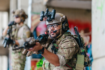 Obraz premium Military tactical operator holds rifle while clearing abandoned concrete building interior