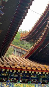 Traditional Chinese temple roof architecture with ornate golden tiles. View of historic palace eaves and intricate building details. Cultural heritage and ancient monument design concept in China.