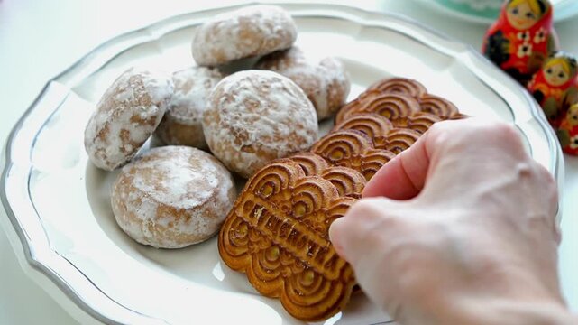 Close-Up of Hand Taking a Condensed Milk Biscuit Next to Russian Pryaniki Gingerbread