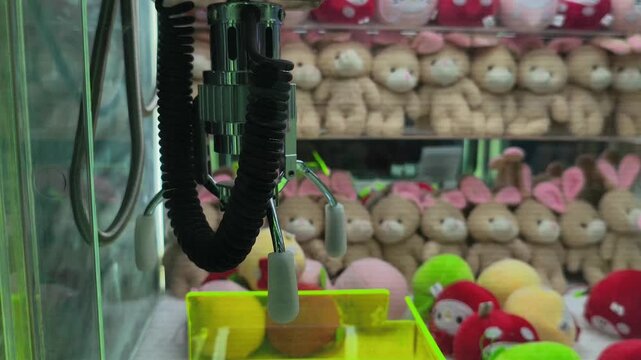 close-up of a metal claw mechanism inside an arcade claw machine, showcasing its mechanical design and precision gripping system used for prize-catching amusement games.