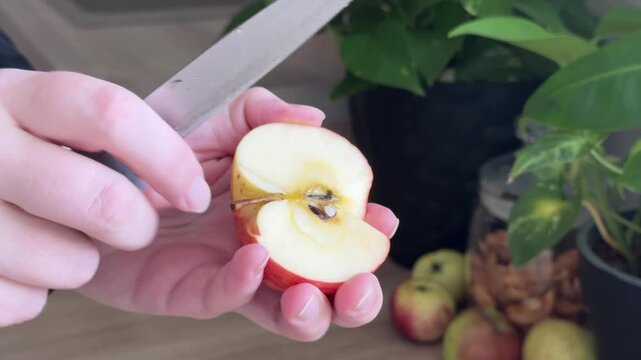 Close-Up of Removing the Stem and Core from a Fresh Apple with a Knife, Preparing Fruit for Homemade Apple Strudel in a Home Kitchen