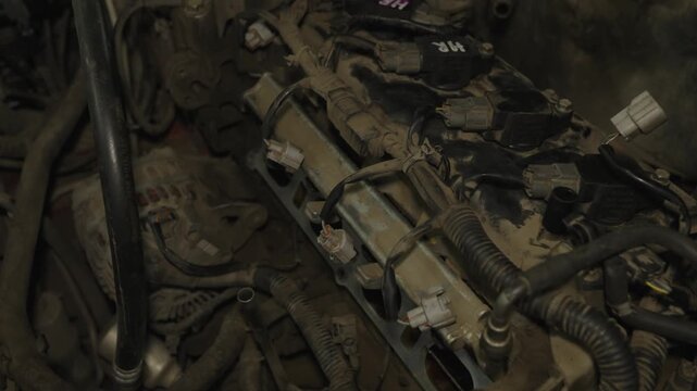Mechanic hands in gloves inspecting and repairing a dusty car engine block bay.