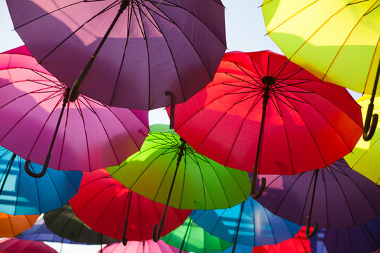 Colorful umbrellas fill the frame in a vibrant outdoor installation, creative background, festive street decoration.
