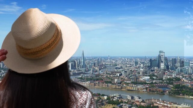 Rear view of a tourist woman looking at the panoramic view of the skyline of London, England, during a sunny summer day