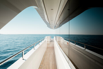Beautiful detail of a superyacht upper deck corridor reflection on the glass windows, featuring the yacht's architectural design © lupiphoto