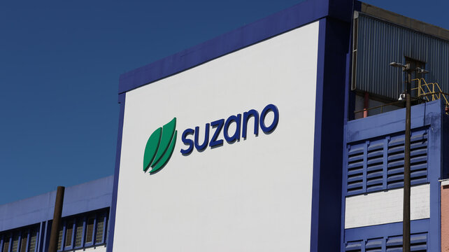 Fachada industrial da Suzano com logomarca e identidade visual em evid&ecirc;ncia sob c&eacute;u claro. Registro realizado em Suzano, SP, no dia 2 de agosto de 2026.