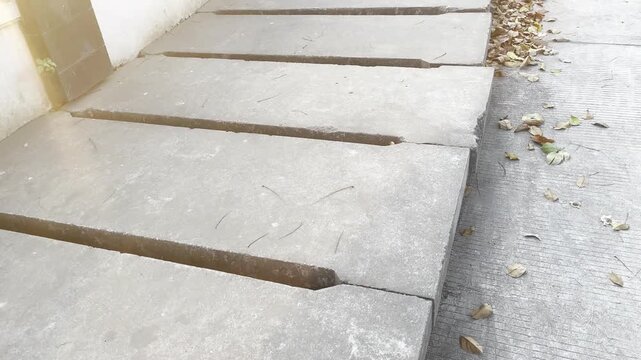 Row of rectangular concrete drainage covers on urban street sidewalk