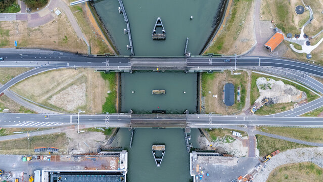 Top down drone view of a bridge over the water on the Afsluitdijk A7 near the Lorentzsluizen in the Netherlands. Infrastructure image showing roads, waterways, lock area and Dutch hydraulic engineerin